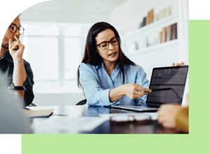 Frau zeigt mit Finger auf Laptop Bildschirm