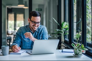 Smiling man_computer_AdobeStock_502231272